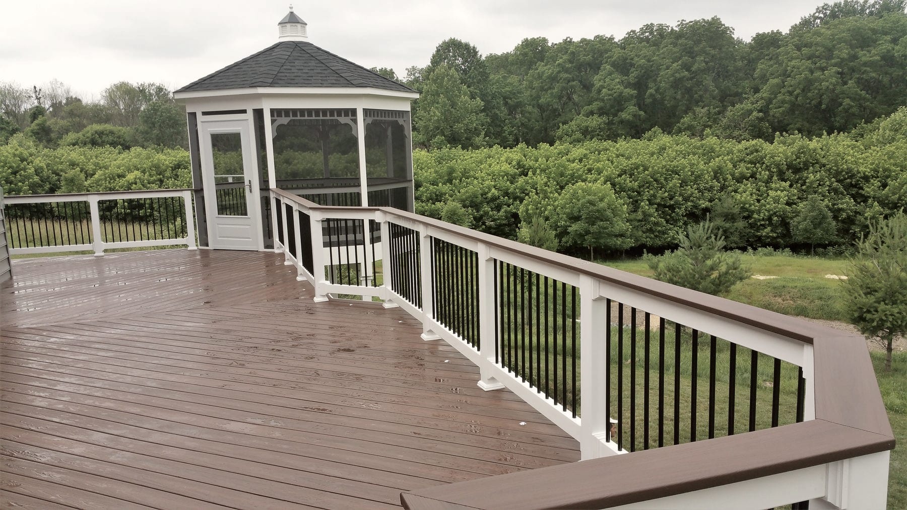 A finished deck with a gazebo, photographed in sunshine